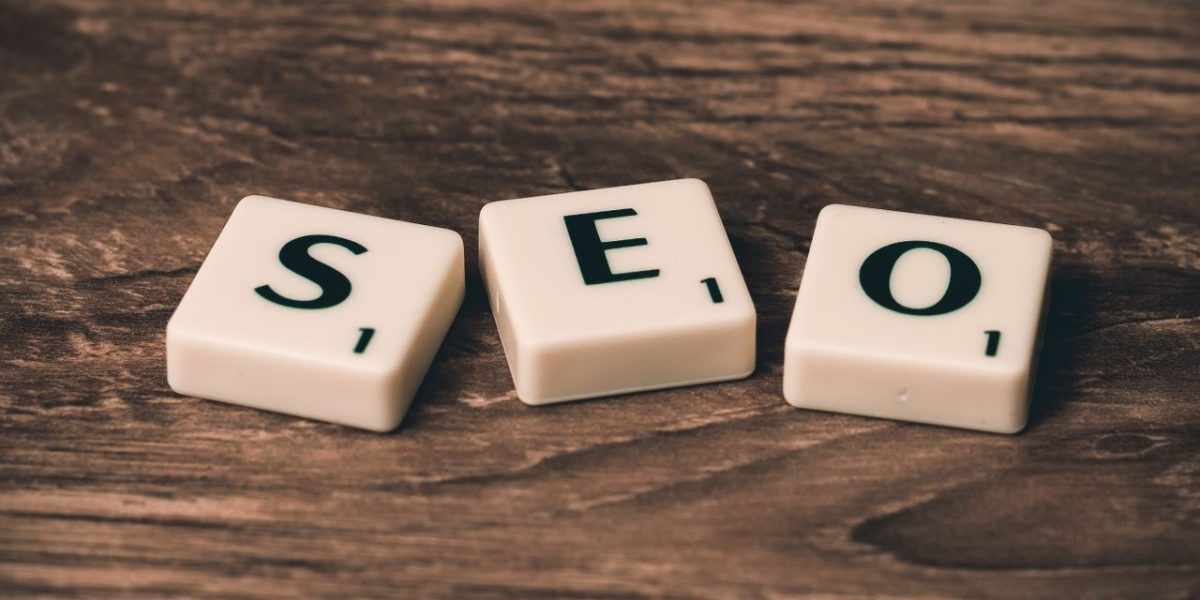 Home Scrabble tiles spelling 'SEO' on a wooden surface. Ideal for digital marketing themes.