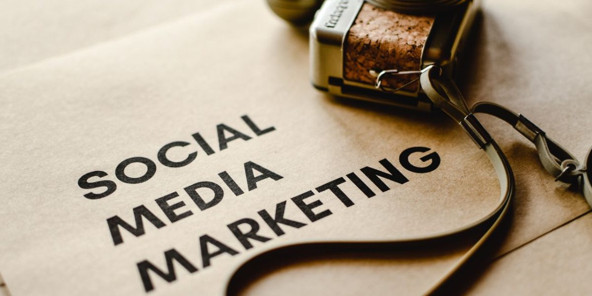 Home Close-up of a camera placed on brown paper with 'Social Media Marketing' text, emphasizing digital marketing themes.